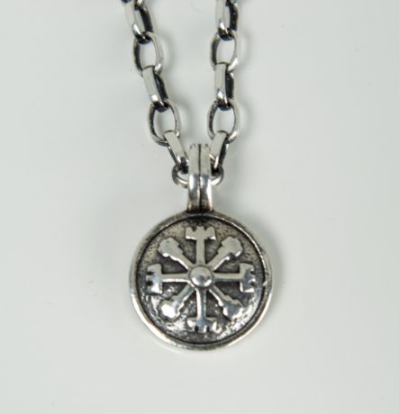 Sterling silver Vegvisir charm close up on white background