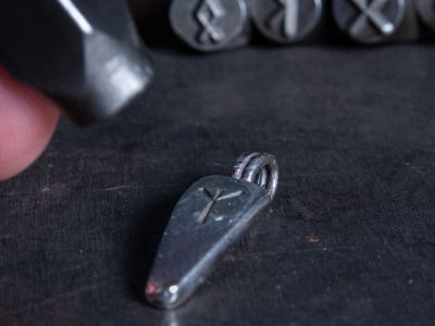 Sterling silver Seidr pendant with rune stamp on bench during stamping process