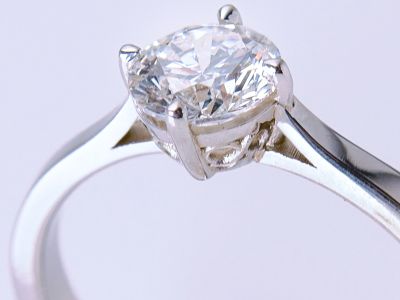Handmade platinum engagement ring with round brilliant cut diamond solitaire photographed against a soft neutral background