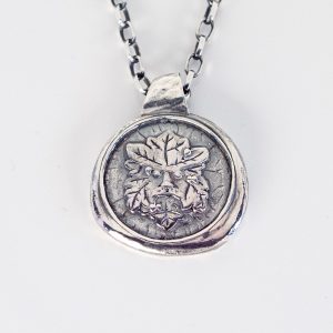 Sterling silver Green Man pendant on chain, front view on white background showing deep relief woodland face design