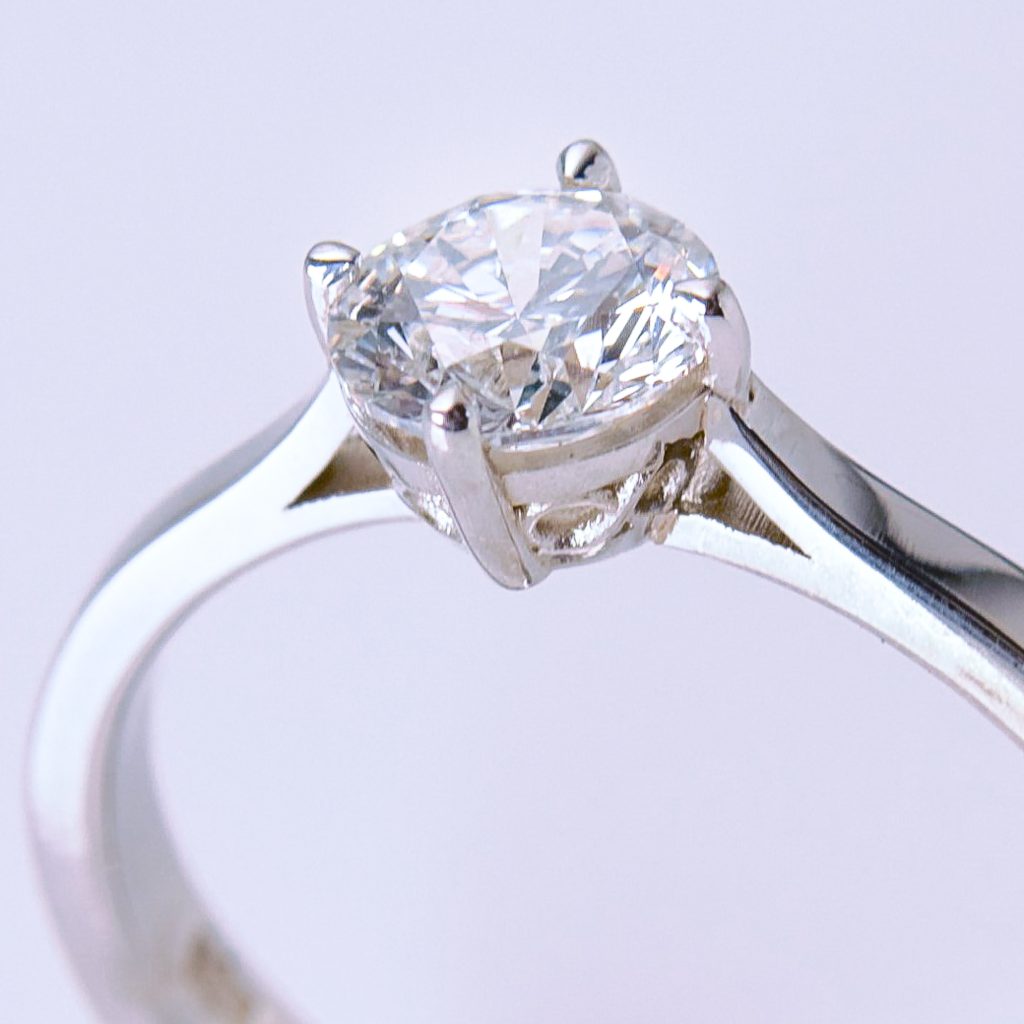 Handmade 9ct white gold engagement ring with round brilliant cut diamond solitaire photographed against a soft neutral background