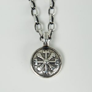 Sterling silver Vegvisir charm close up on white background