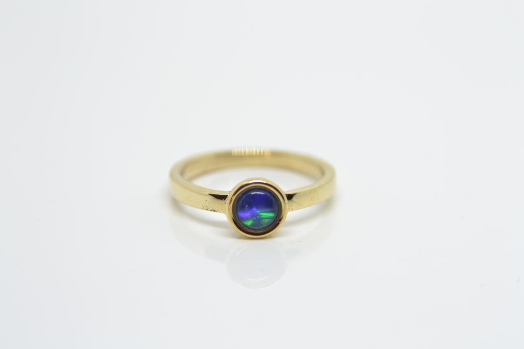 Simple yellow gold engagement ring with customer-supplied synthetic blue stone